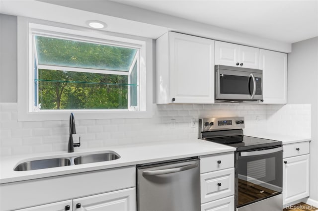 kitchen featuring sink, white cabinetry, stainless steel appliances, and tasteful backsplash