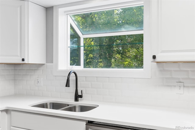 kitchen with white cabinets, backsplash, and sink