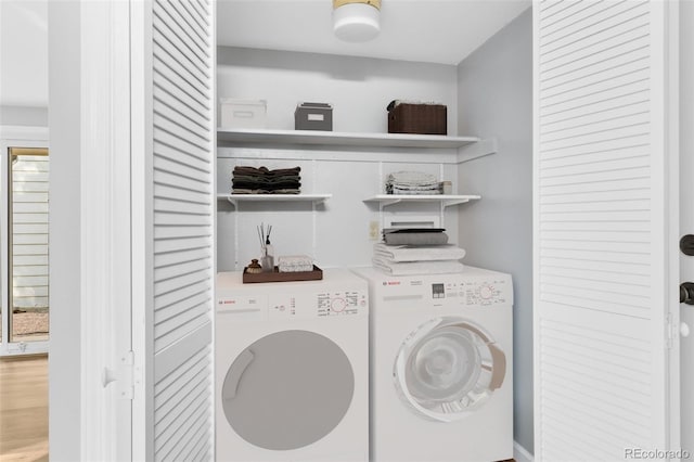 laundry room with hardwood / wood-style floors and separate washer and dryer