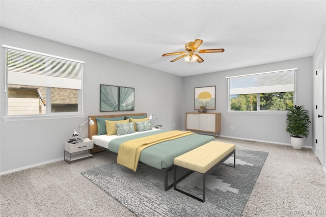 bedroom featuring carpet, ceiling fan, and a textured ceiling