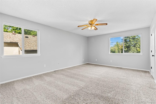 carpeted empty room with ceiling fan and a textured ceiling