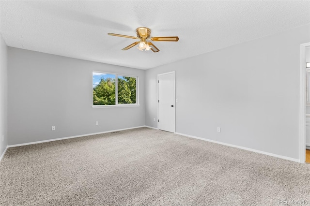 empty room with carpet, ceiling fan, and a textured ceiling