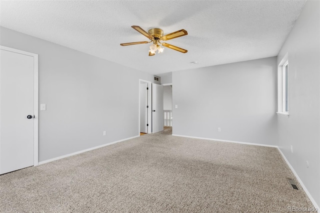 spare room featuring carpet, ceiling fan, and a textured ceiling