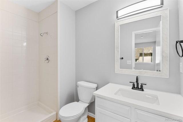 bathroom featuring vanity, toilet, and tiled shower