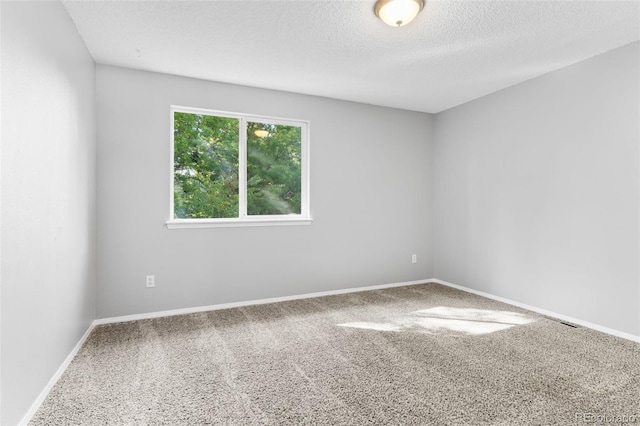 carpeted spare room with a textured ceiling