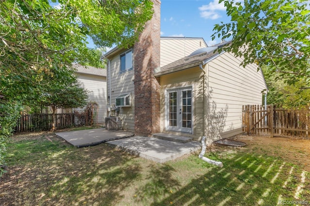 rear view of house with a yard, a patio, and french doors