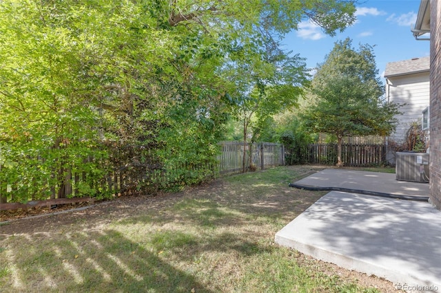 view of yard with cooling unit and a patio