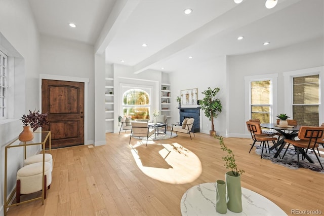 foyer entrance featuring plenty of natural light, light hardwood / wood-style flooring, and beamed ceiling