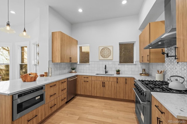 kitchen with extractor fan, stainless steel appliances, backsplash, hanging light fixtures, and sink