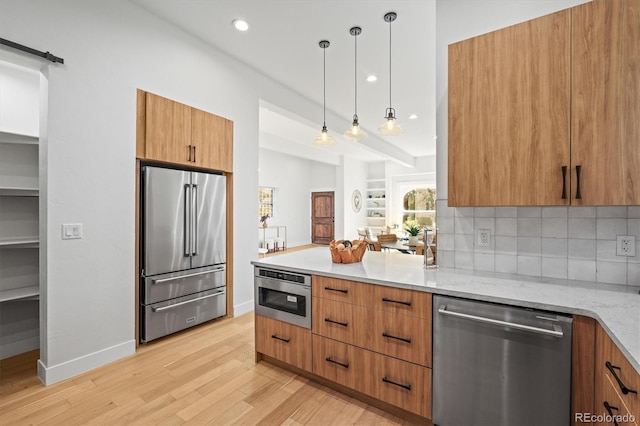 kitchen with appliances with stainless steel finishes, decorative light fixtures, tasteful backsplash, light hardwood / wood-style floors, and light stone counters