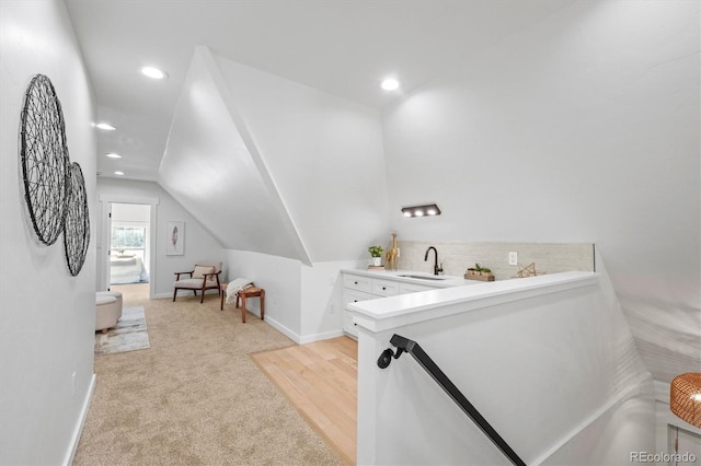 bathroom with vaulted ceiling, sink, and decorative backsplash