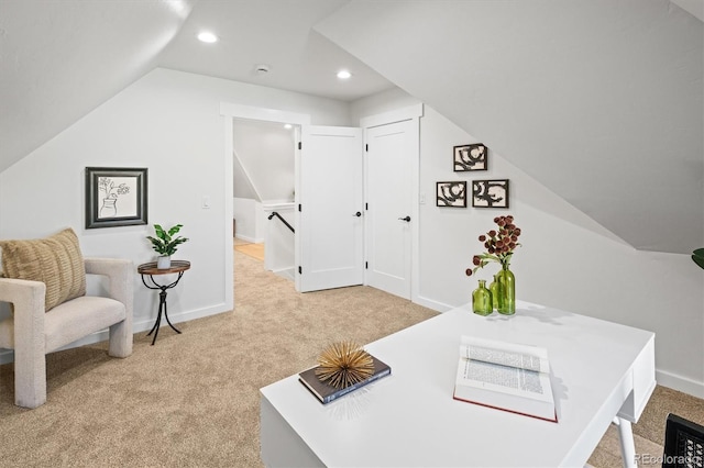 carpeted home office featuring vaulted ceiling