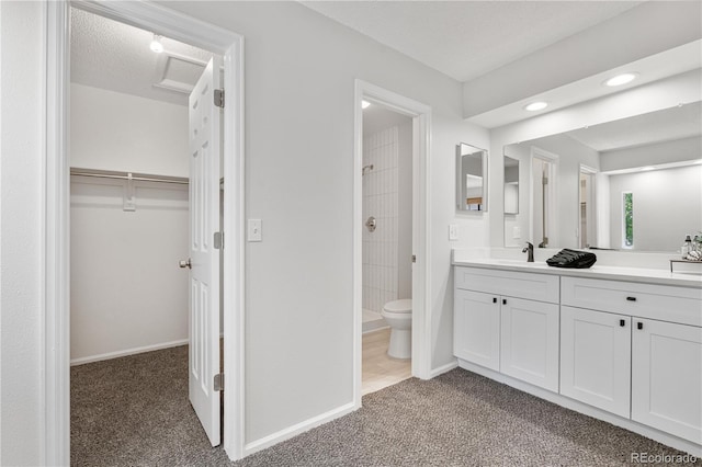 full bathroom with a tile shower, vanity, toilet, baseboards, and a spacious closet