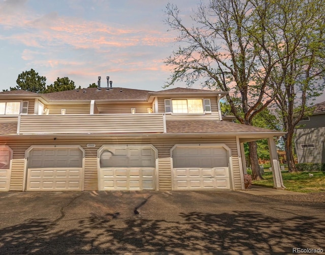 view of front of home featuring a balcony and a shingled roof