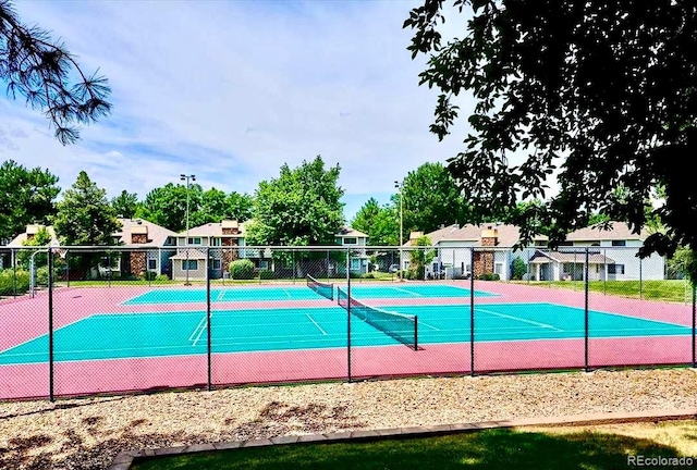 view of pool featuring a tennis court and fence