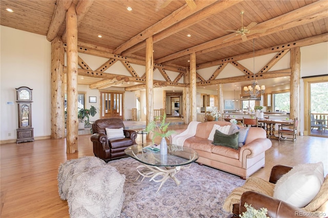 living area featuring beam ceiling, high vaulted ceiling, ceiling fan with notable chandelier, wood finished floors, and wooden ceiling