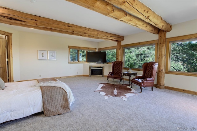 bedroom featuring beamed ceiling, a tile fireplace, baseboards, and carpet floors