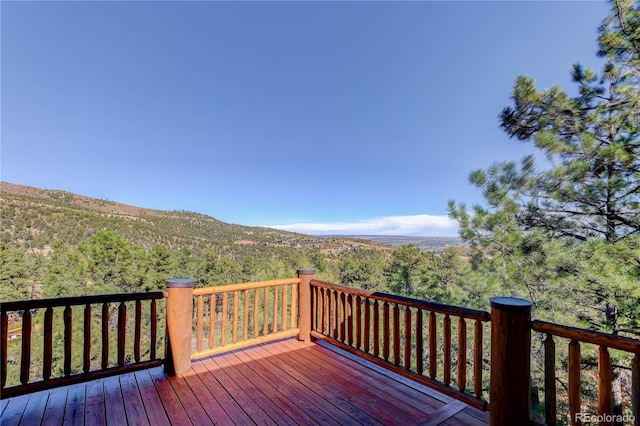 deck featuring a mountain view and a view of trees