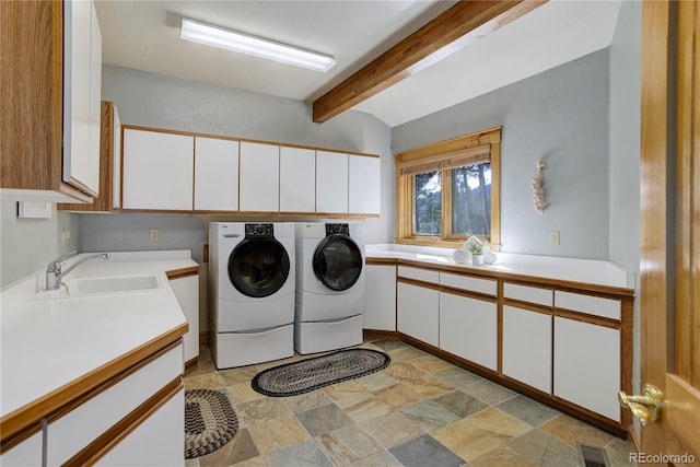 laundry area with visible vents, stone finish floor, cabinet space, independent washer and dryer, and a sink