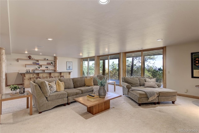 living room featuring recessed lighting, expansive windows, baseboards, and light colored carpet