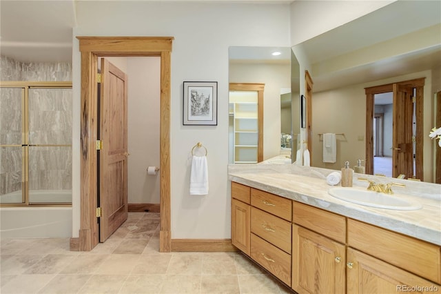 full bath with vanity, tile patterned flooring, baseboards, and shower / bath combination with glass door