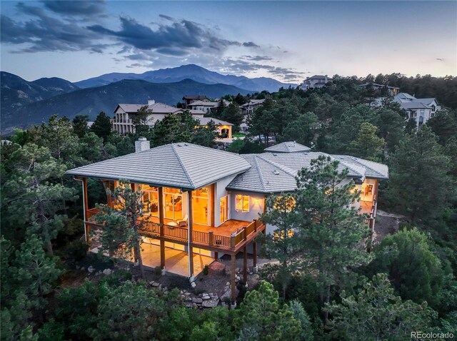 4440 Monitor Rock Ln, Colorado Springs, CO 80904 - back of property at dusk featuring a chimney, a deck with mountain view, and a tile roof
