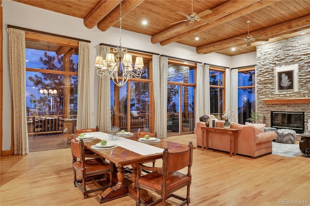 4440 Monitor Rock Ln, Colorado Springs, CO 80904 - dining space with a wood ceiling with exposed beams, a chandelier, ceiling fan, light wood-type flooring, and a stone fireplace