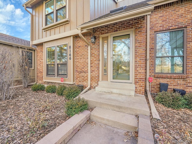 entrance to property with board and batten siding and brick siding