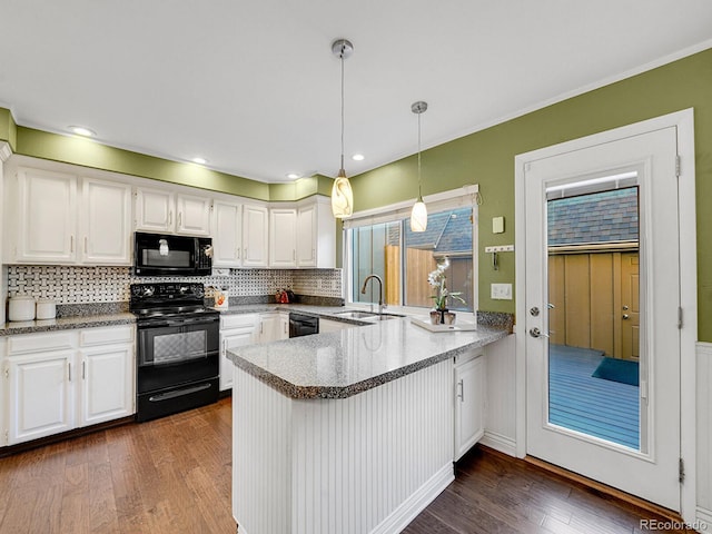 kitchen featuring white cabinetry, a sink, a peninsula, and black appliances