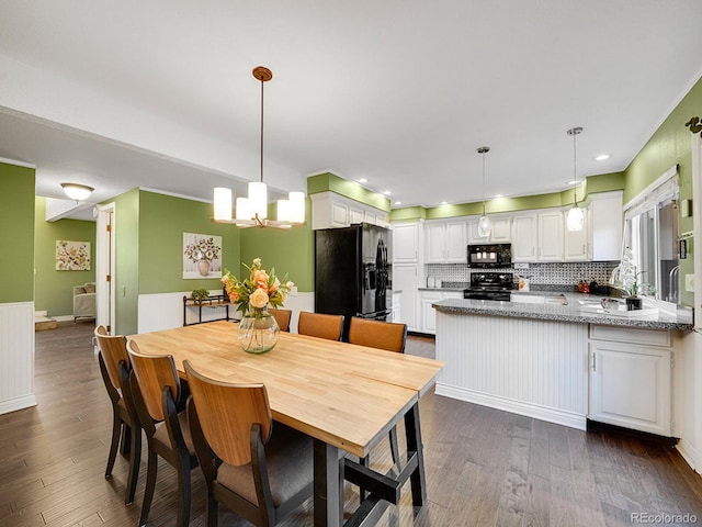 dining area with dark wood-style floors, a notable chandelier, and recessed lighting