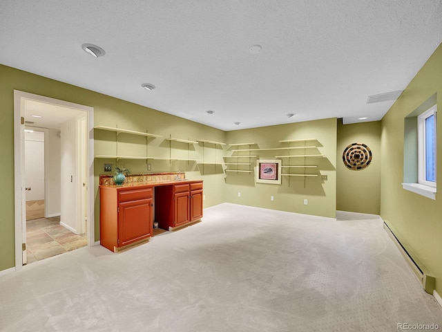 kitchen with a textured ceiling, light colored carpet, a sink, baseboards, and baseboard heating