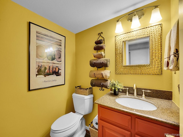 half bath featuring toilet, a textured ceiling, and vanity