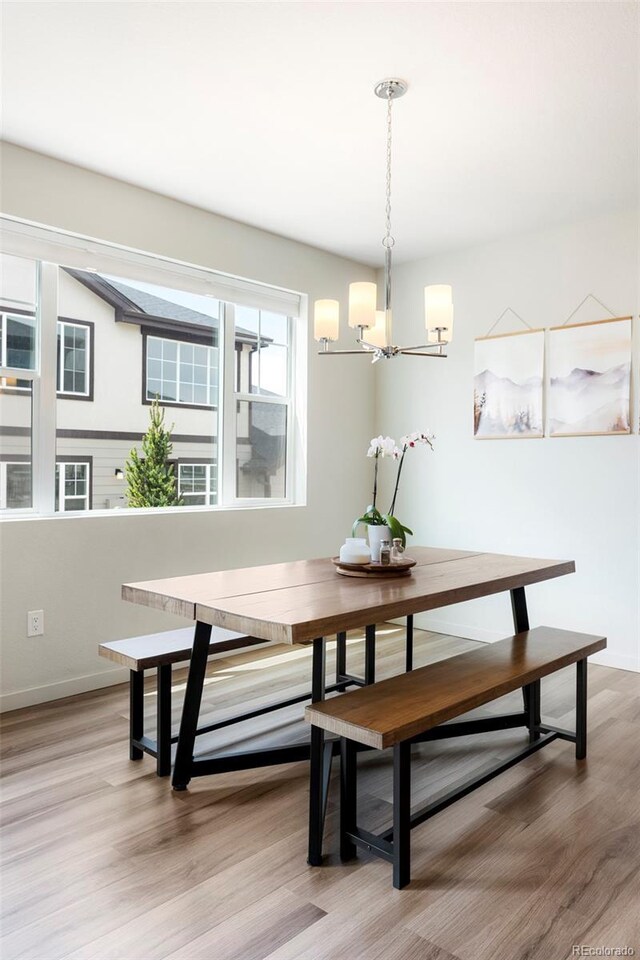 1849 S Helena St, Aurora, CO 80017 - dining space with a chandelier, light wood finished floors, and baseboards