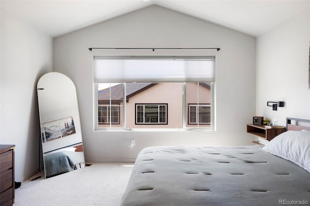 carpeted bedroom with lofted ceiling and baseboards