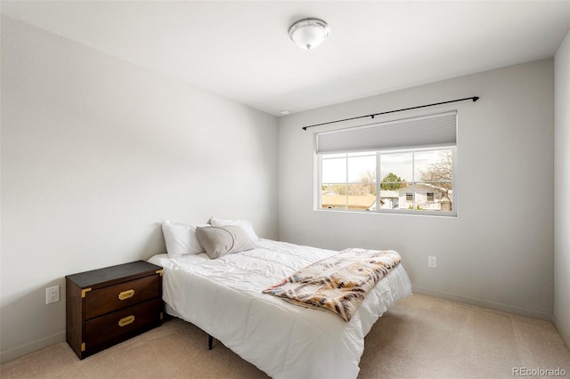 bedroom with light colored carpet and baseboards