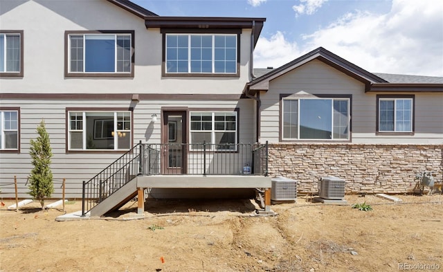 view of front of house with central AC unit and stone siding