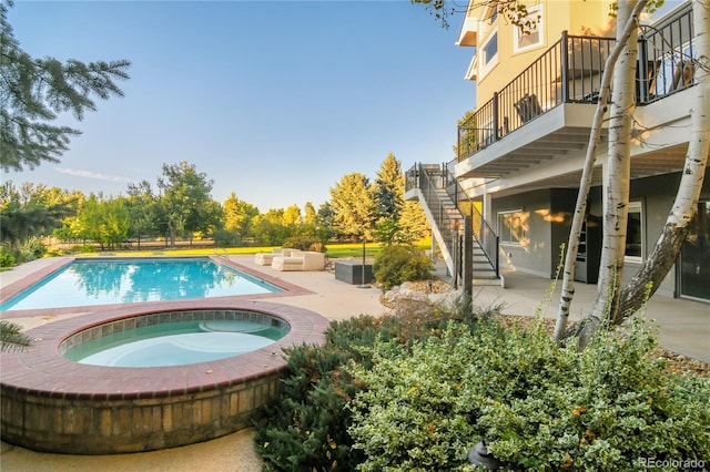 view of swimming pool with an in ground hot tub, an outdoor hangout area, and a patio