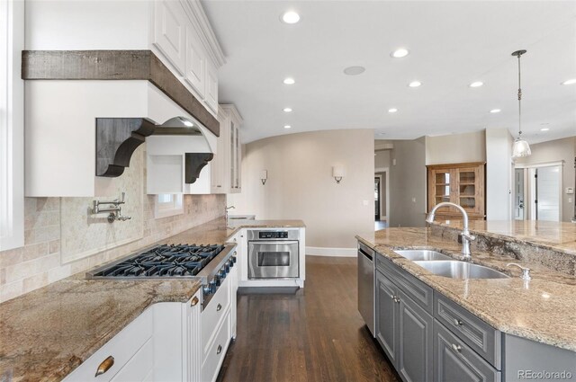 kitchen featuring appliances with stainless steel finishes, pendant lighting, gray cabinetry, white cabinets, and light stone countertops