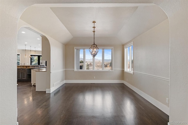 unfurnished dining area featuring plenty of natural light, dark wood-type flooring, sink, and a chandelier