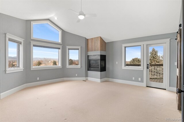 unfurnished living room with high vaulted ceiling, light carpet, and ceiling fan