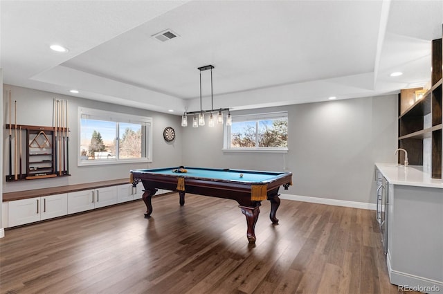 game room with a wealth of natural light, wood-type flooring, pool table, and a raised ceiling