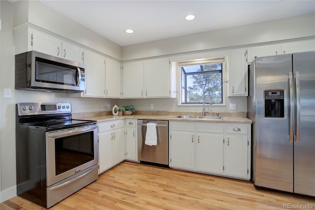 kitchen with white cabinets, light hardwood / wood-style floors, sink, and stainless steel appliances