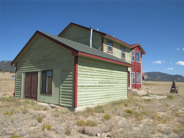 view of property exterior featuring a mountain view and a rural view