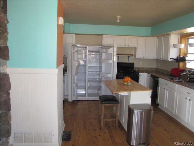 kitchen with a center island, black range with gas stovetop, dark hardwood / wood-style flooring, and white cabinets