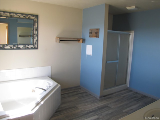 bathroom with wood-type flooring and shower with separate bathtub