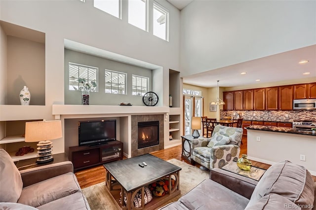 living room featuring a fireplace, light hardwood / wood-style flooring, and a wealth of natural light