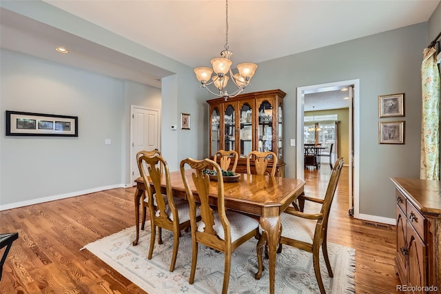 dining room with an inviting chandelier and light wood-type flooring