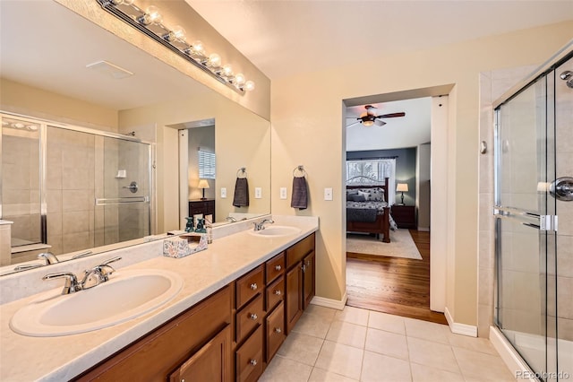 bathroom with tile patterned flooring, vanity, ceiling fan, and an enclosed shower