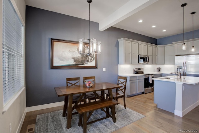 kitchen with visible vents, stainless steel appliances, light countertops, light wood-type flooring, and a sink