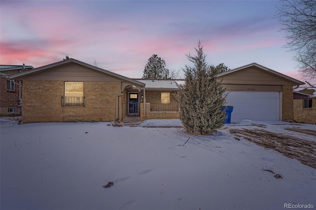 ranch-style home with a garage, brick siding, and a porch